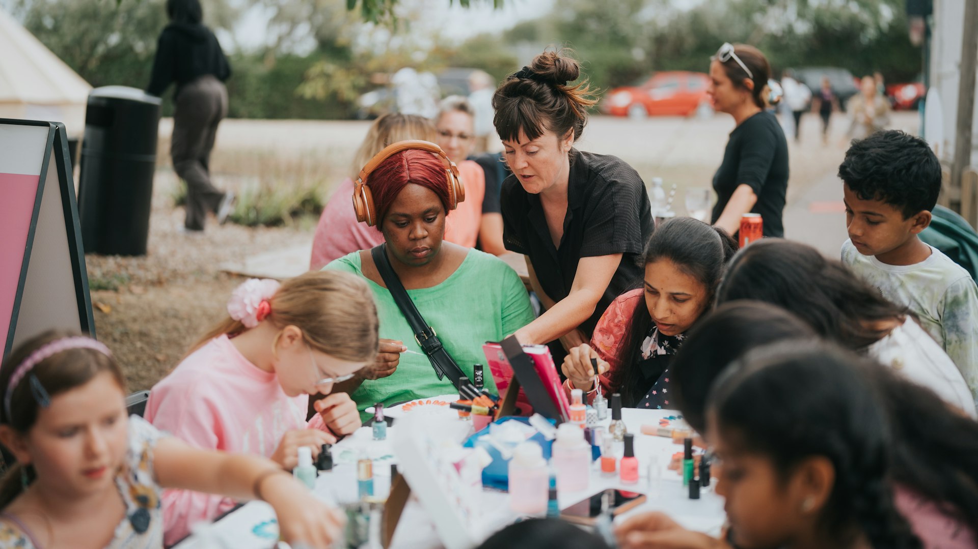 A large group of people having fun making nail art