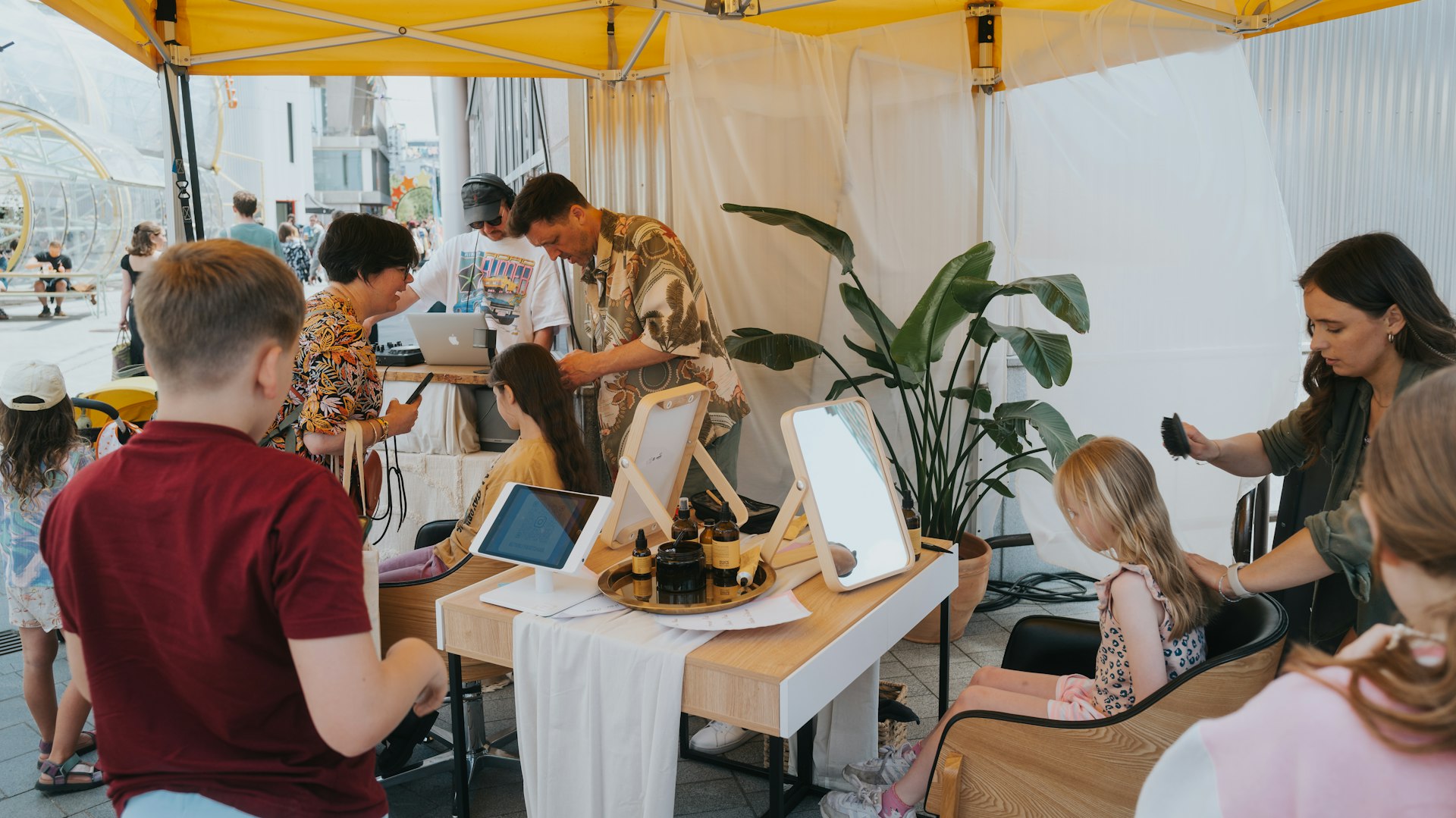 Kids getting braids in their hair at the stall