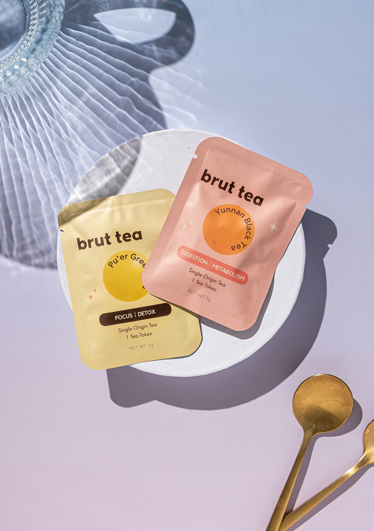 Two packs of tea bags, teaspoon and water