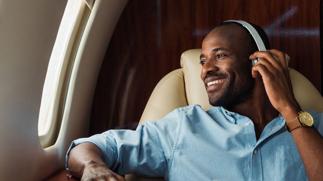 Homme écoutant de la musique avec un casque dans un jet privé