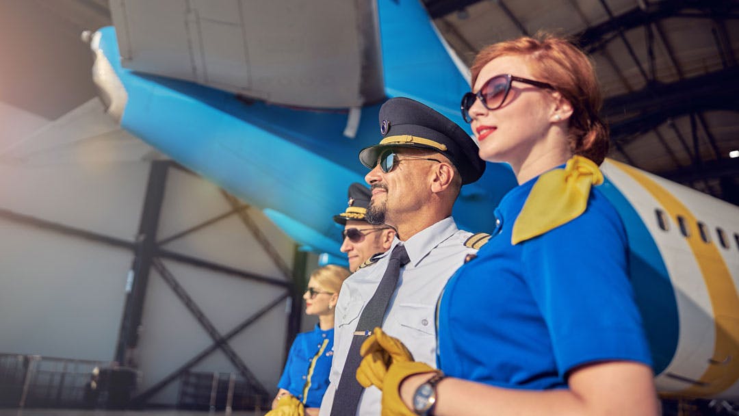 Un commandant et des hôtesses d’un avion aux couleurs spécifiques