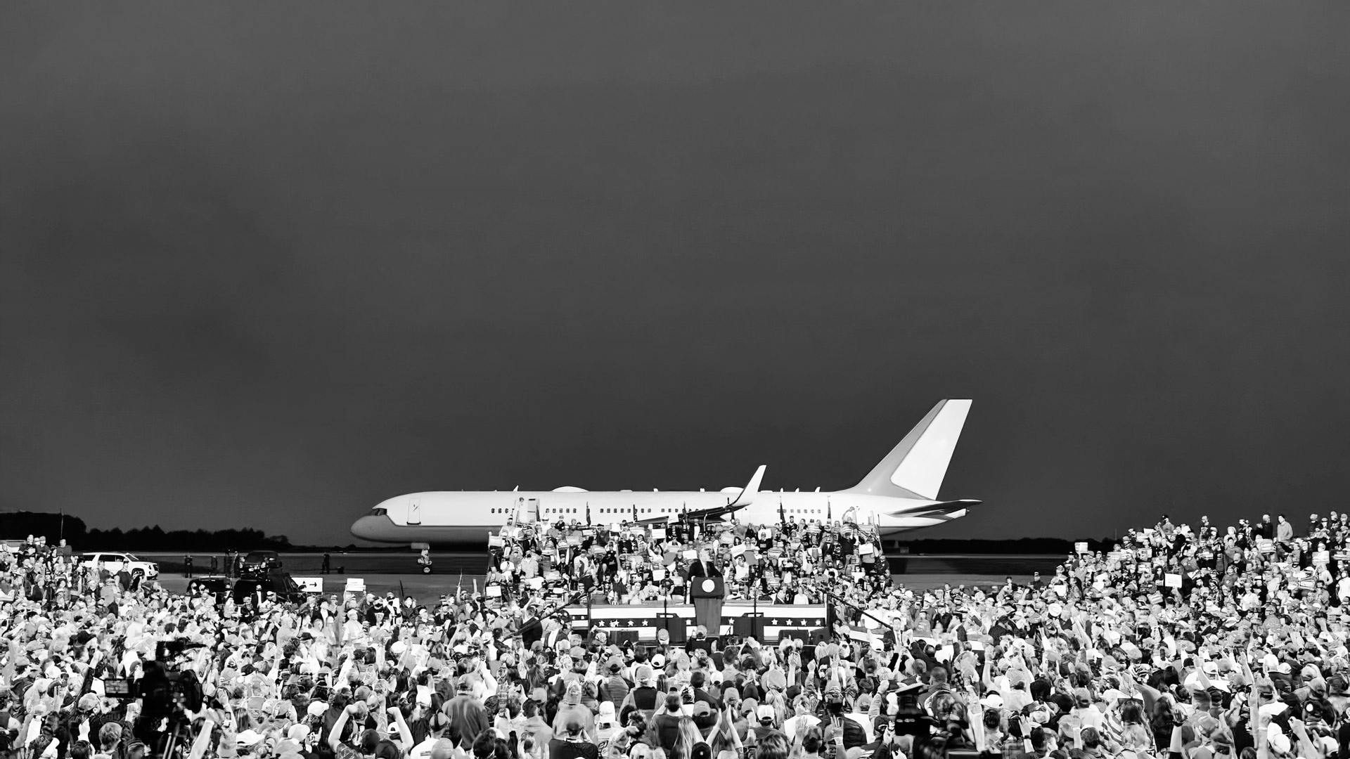 Personas que asisten a una reunión política delante de un avión. Alquile un avión para transportar a su personal en las giras de reuniones políticas.