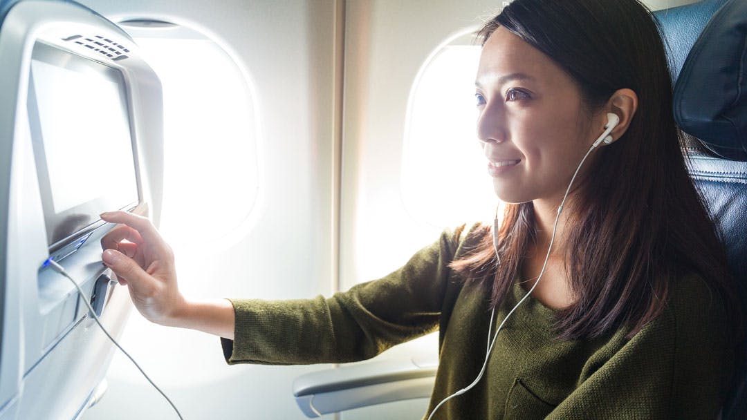 Femme en regardant un film à bord d'avion