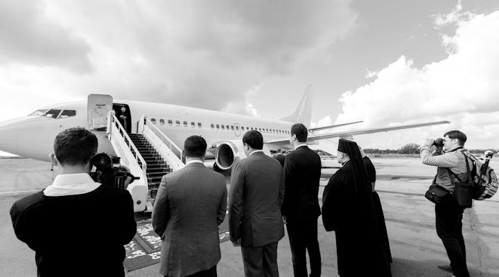 Funcionarios recibiendo a una delegación deportiva oficial en el aeropuerto. El flete de un avión es una forma eficaz de transportar a las delegaciones oficiales.