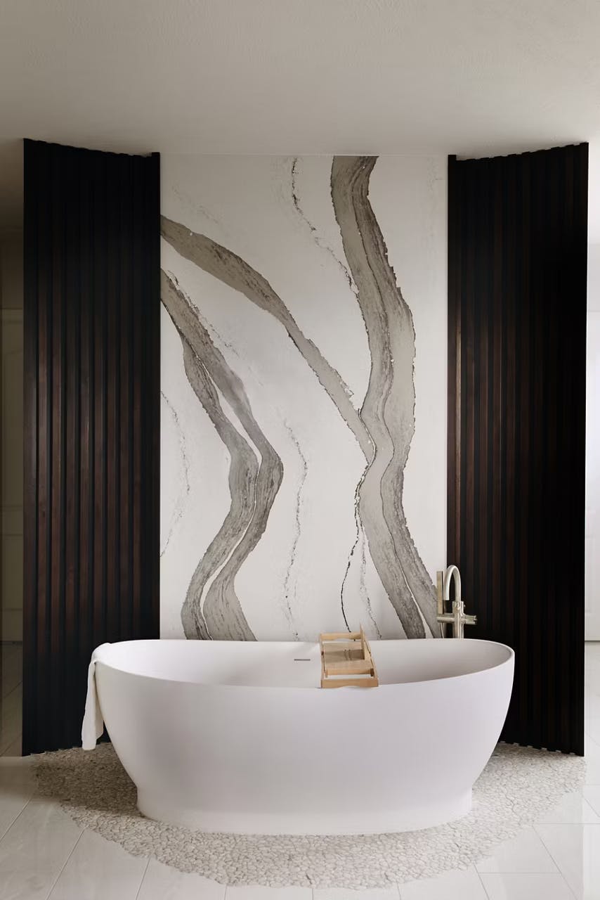 Standalone bath on a Skara Brae by Cambria wall surface