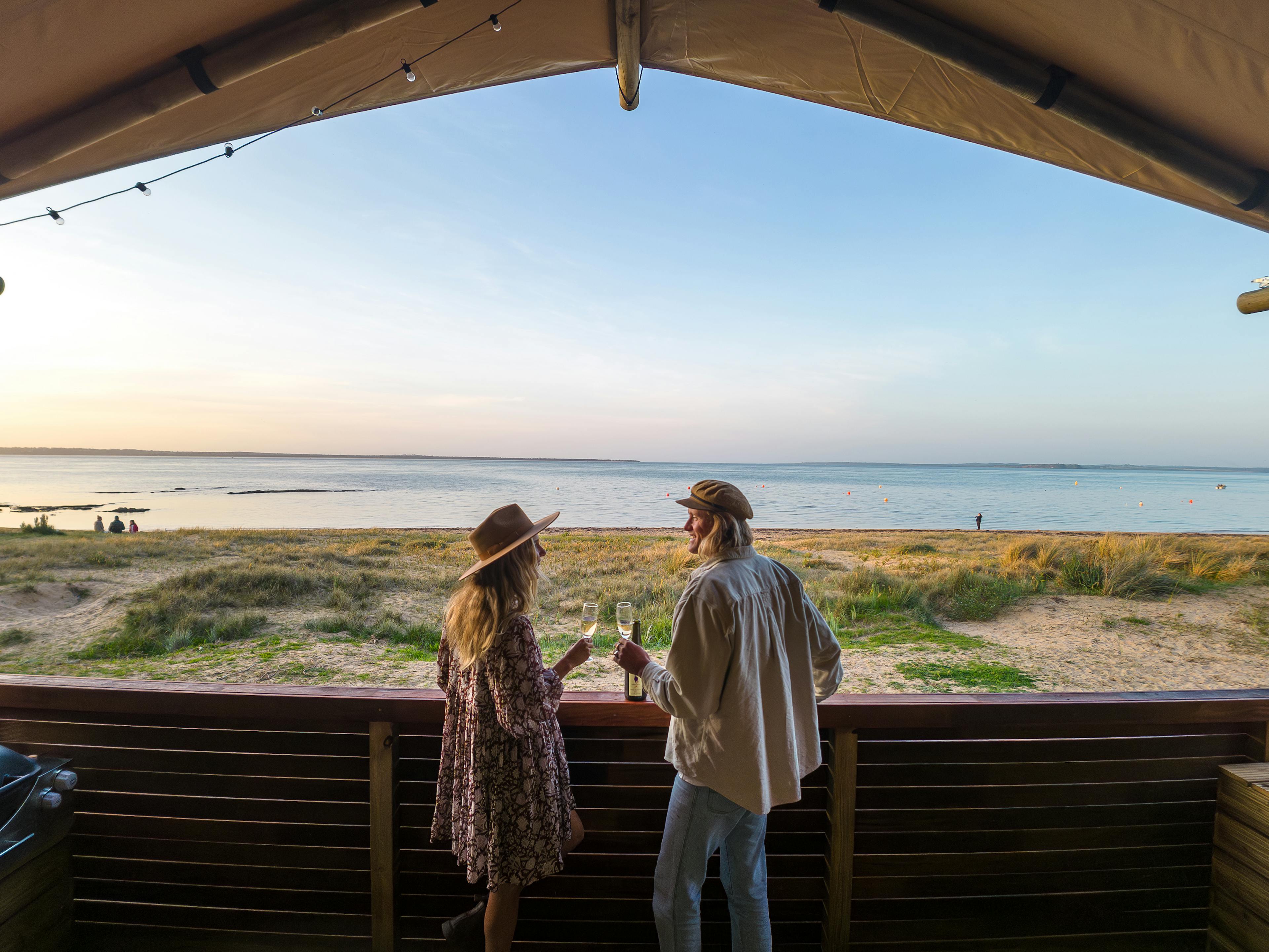 Girl and boy drinking at beach 