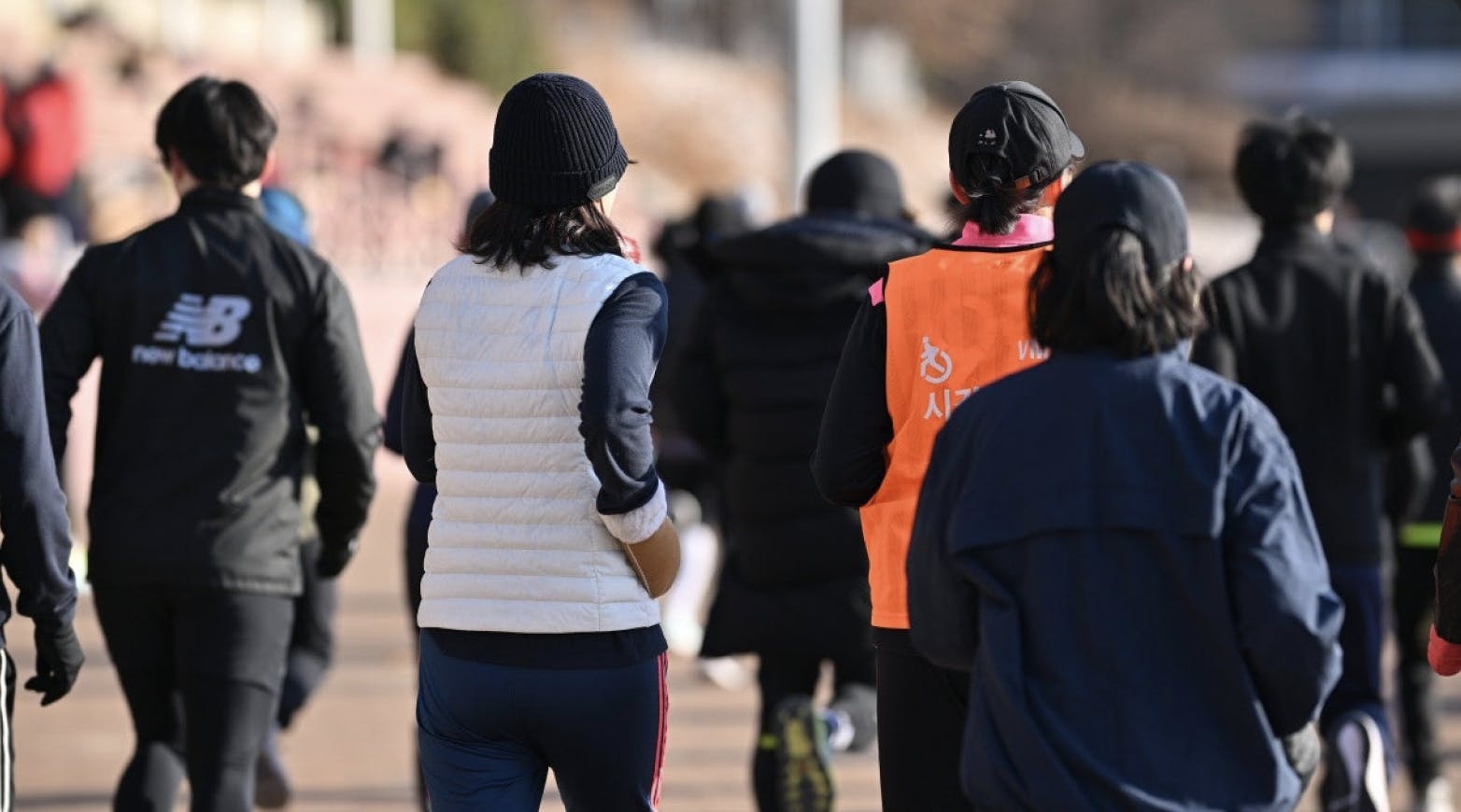 많은 사람들 사이에서 달리기를 하고 있는 뒷 모습