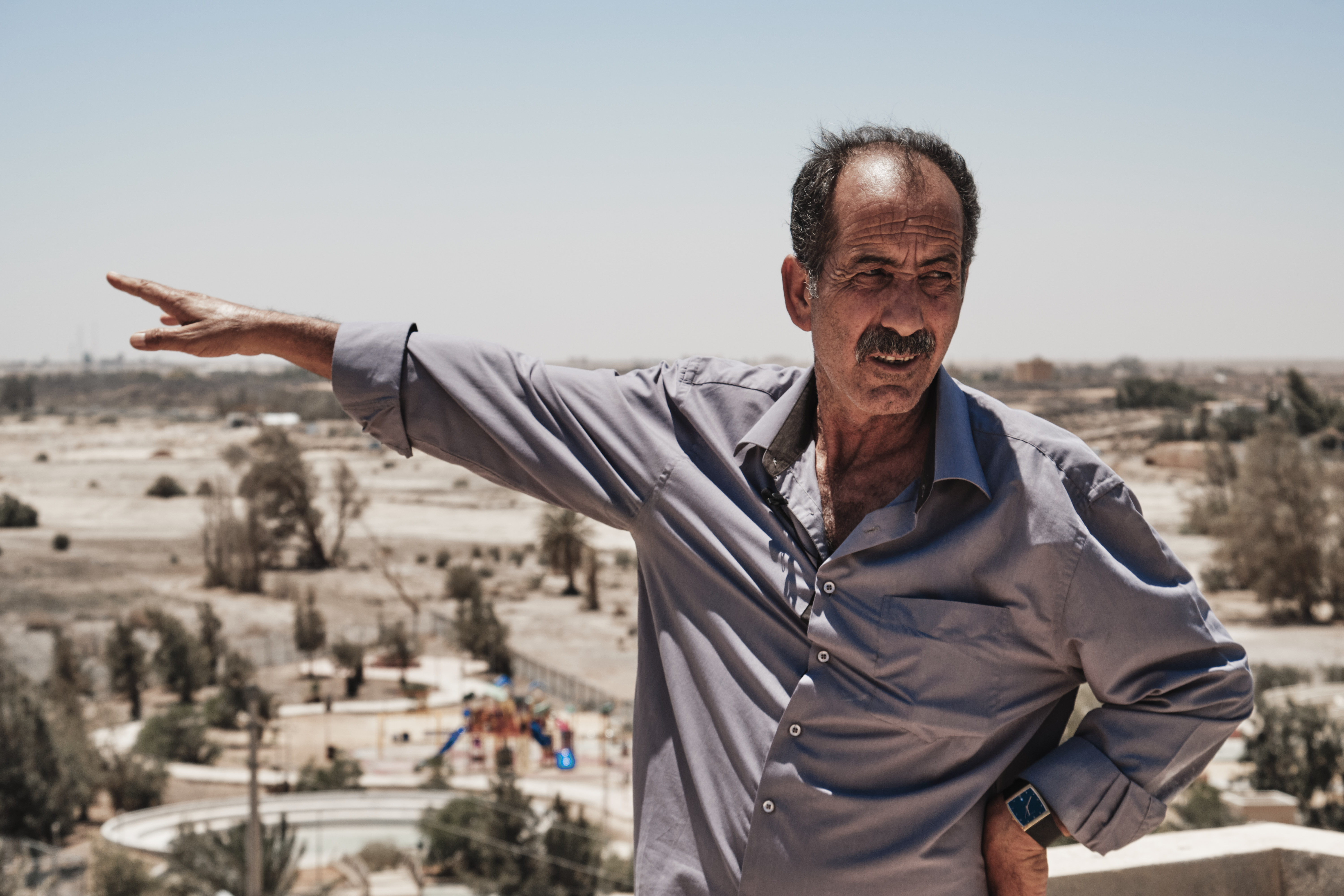 Resident points to the former wetland oasis, Azraq, Jordan. August 2019 Photograph: Guido van Helten