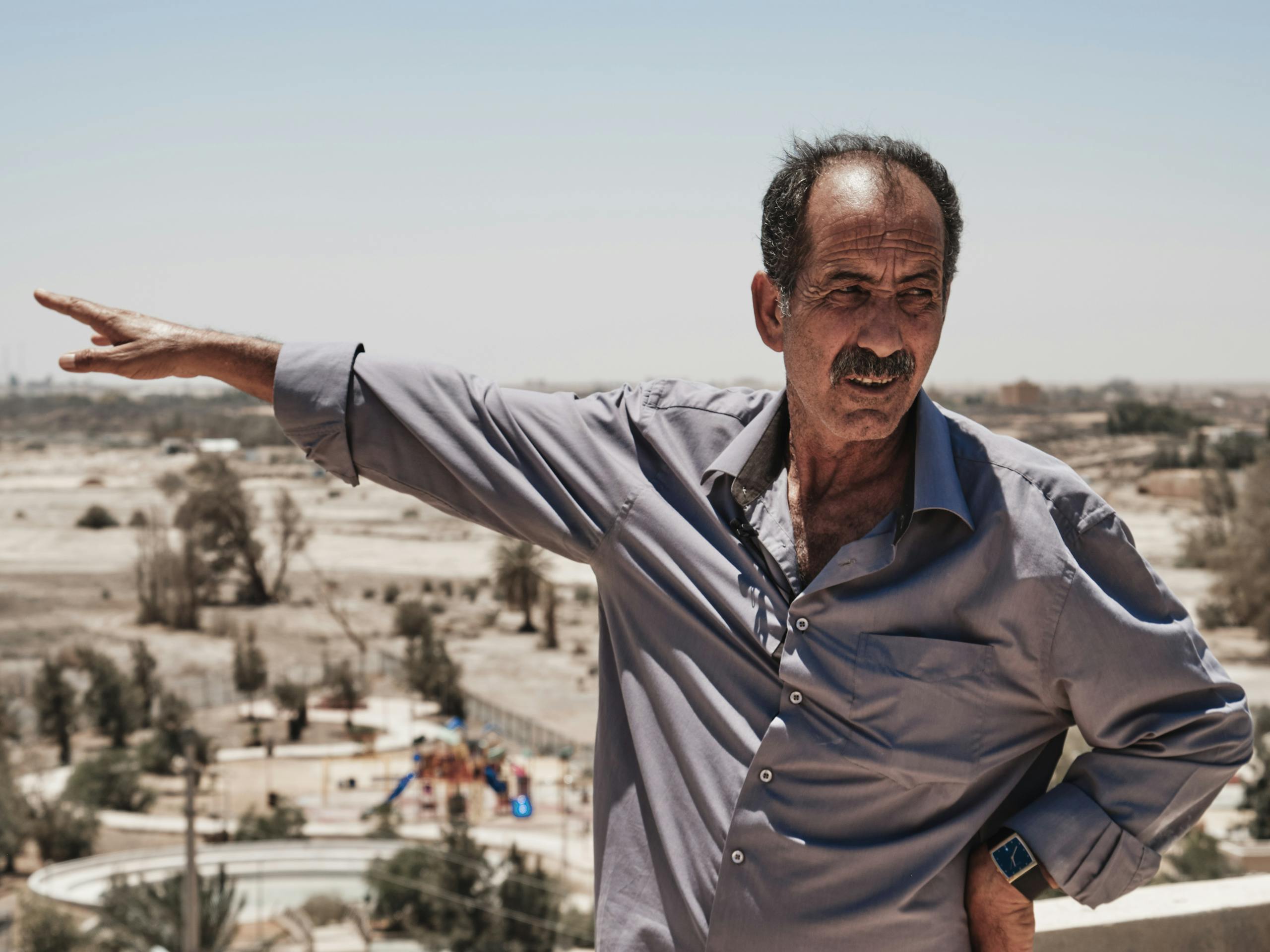 Resident points to the former wetland oasis, Azraq, Jordan. August 2019 Photograph: Guido van Helten