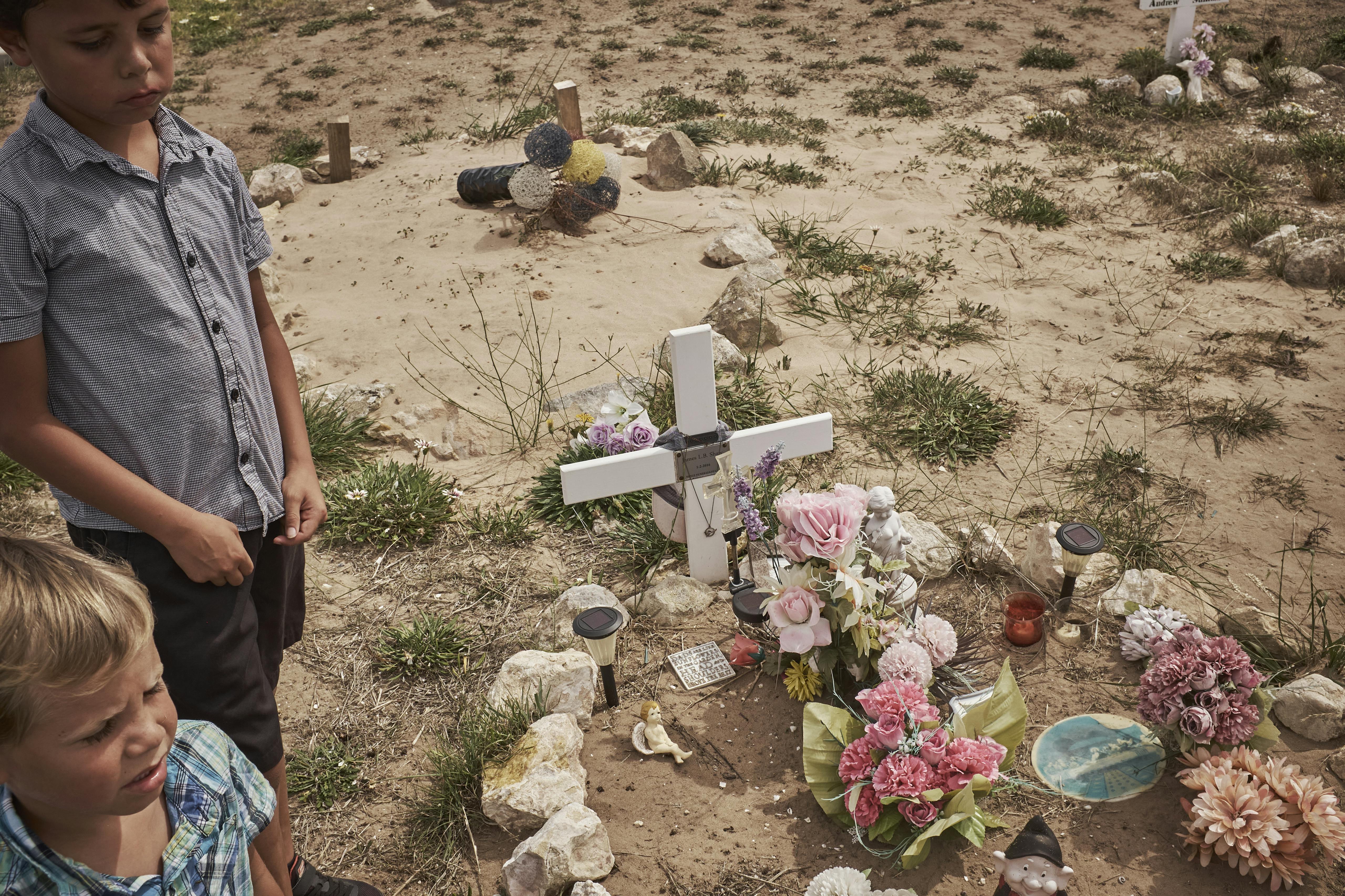 Local children and the grave of a close relative in Raukkan Cemetery Raukkan, South Australia. March 2017 Photographs: Guido van Helten