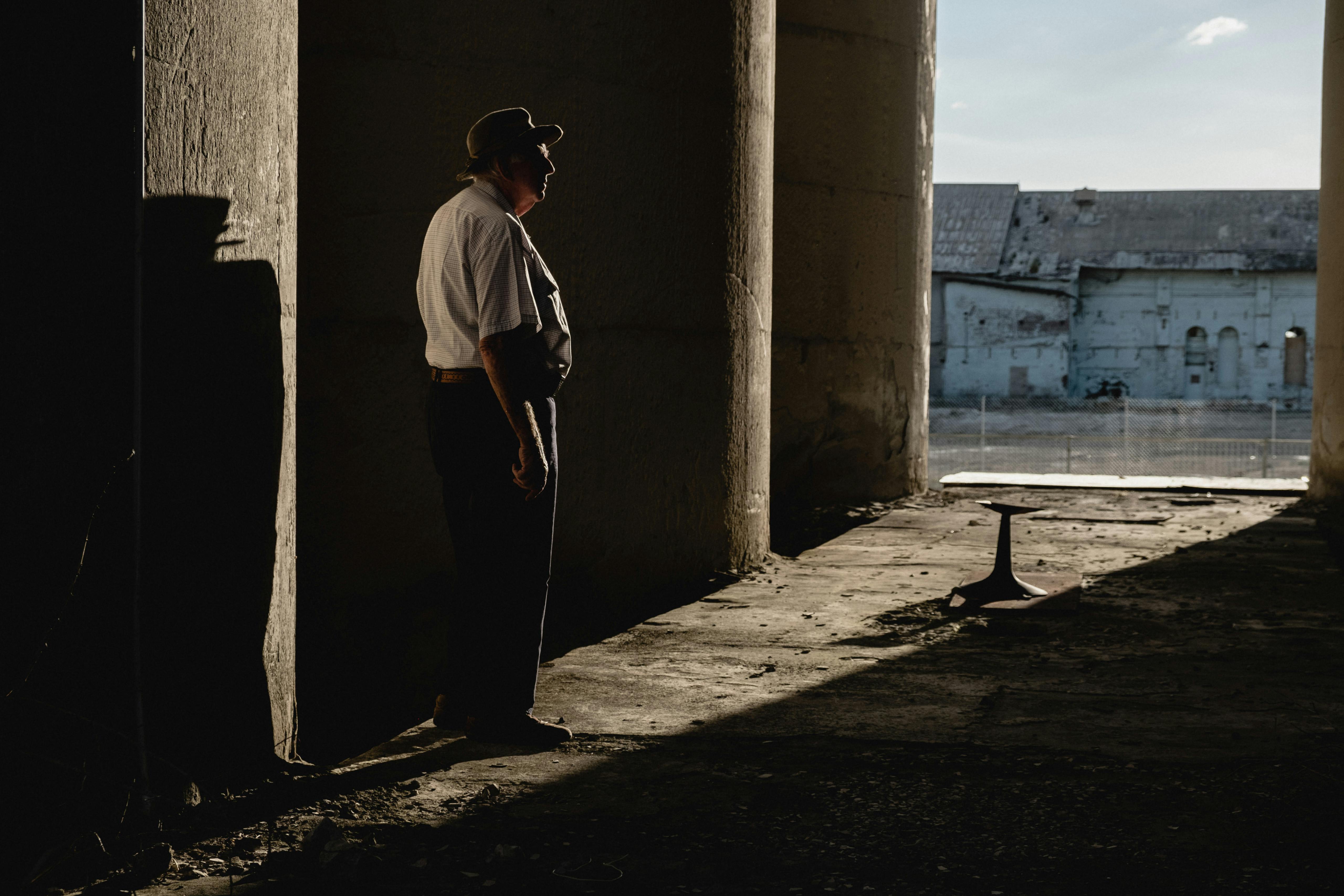 Coleman stands in the shadows of the silos Portland, NSW, Australia. May 2018 Photographs: Guido van Helten 