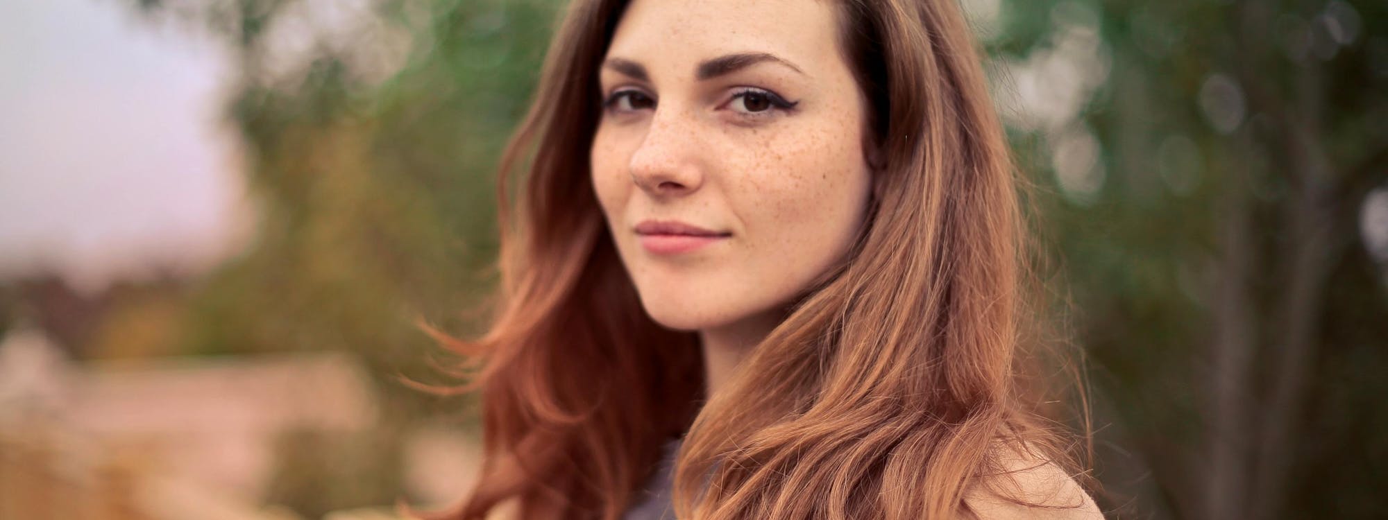 Frau lächelt verschmitzt auf einer Brücke