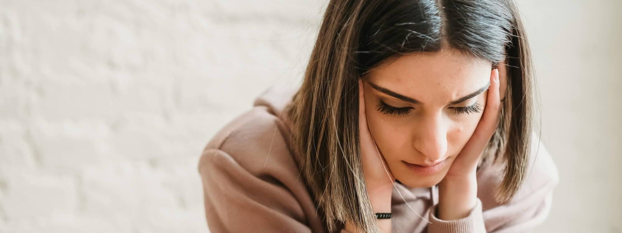 Frau stützt sich auf Tisch mit beiden Armen ab