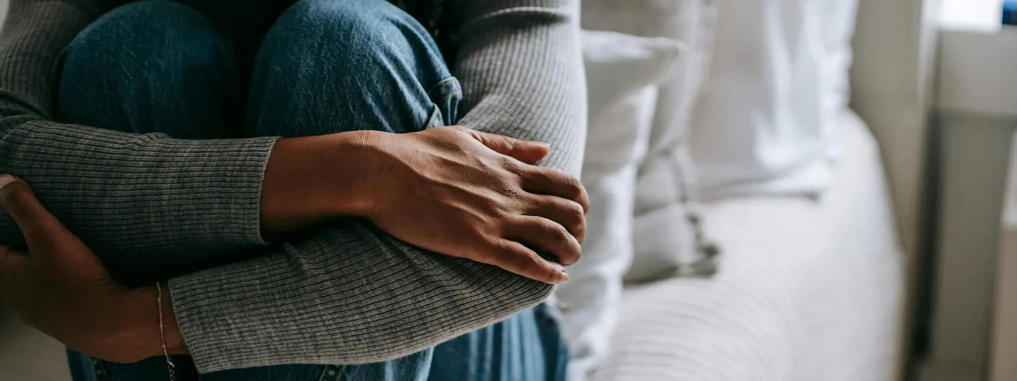 Mann umklammert seine Beine