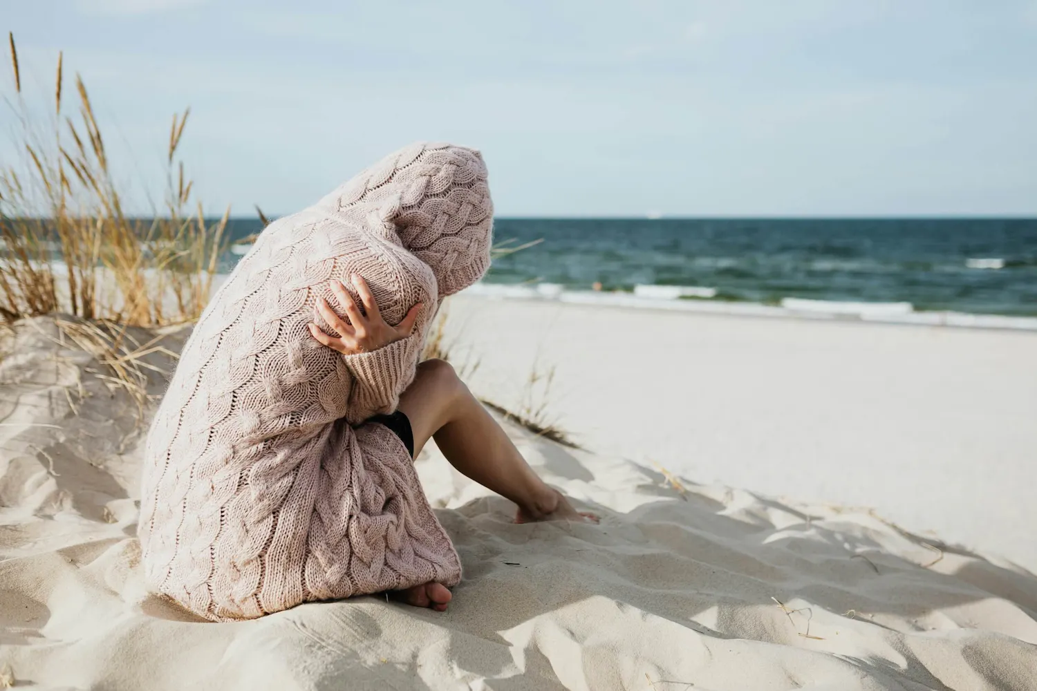 Frau sitzt depressiv am Strand Frau sitzt depressiv am Strand