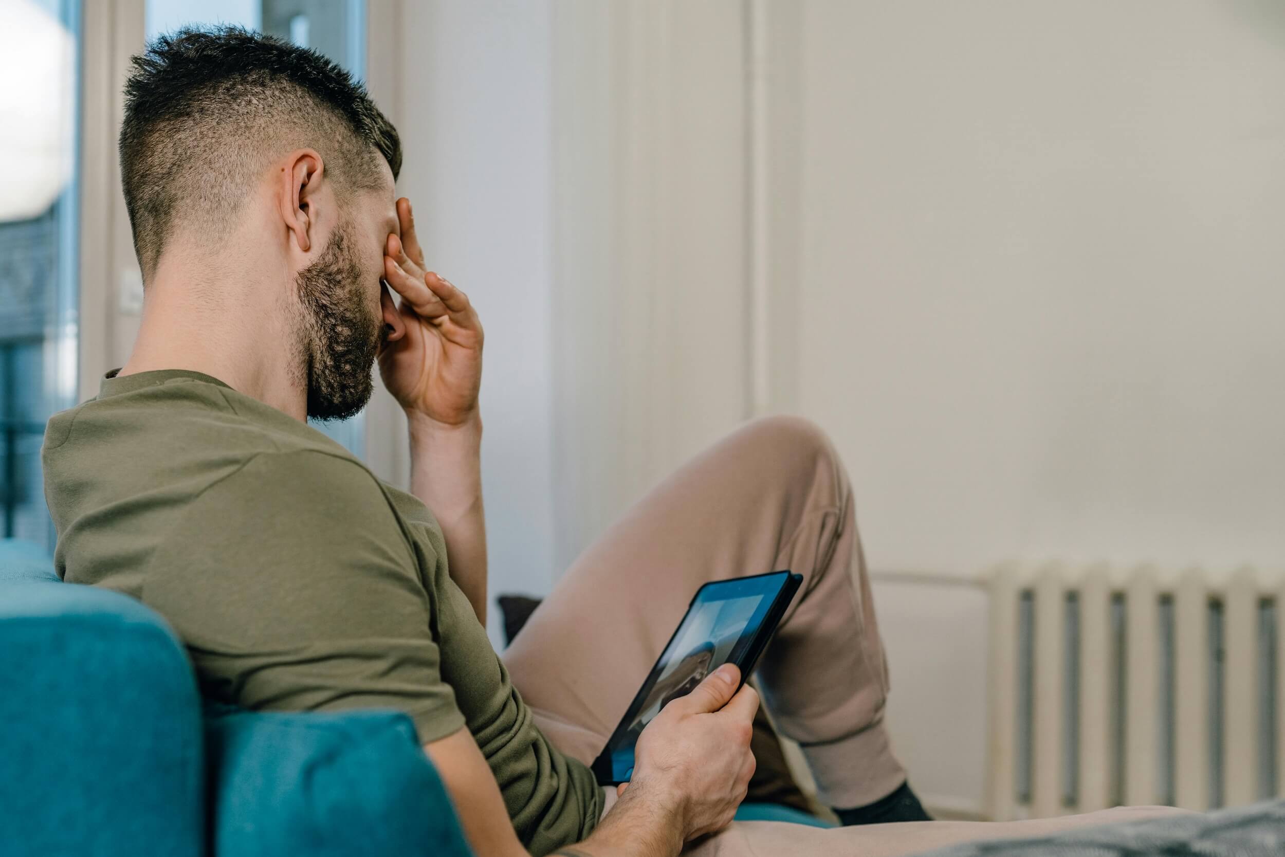 Mann mit rezidivierender depressiver Störung sitzt auf dem Sofa