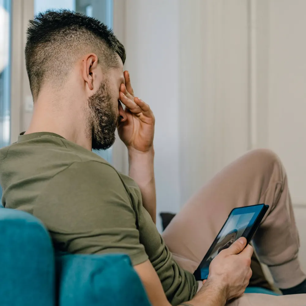 Mann mit rezidivierender depressiver Störung sitzt auf dem Sofa