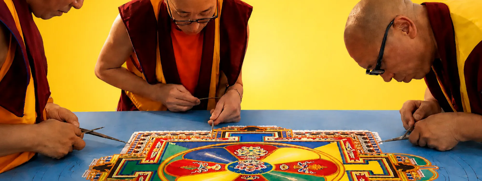 Buddhistische Mönche streuen Sandmandala