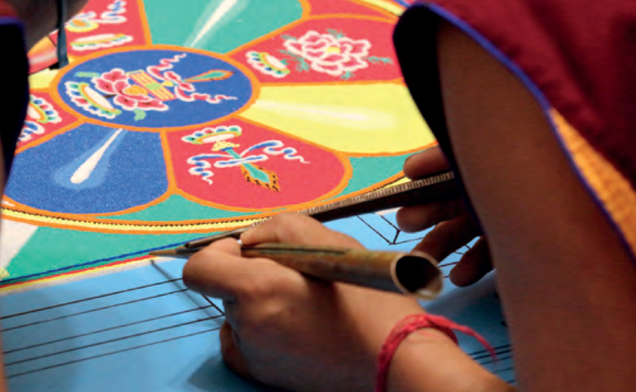 Tibetische Mönche streuen kunstvolle Mandalas