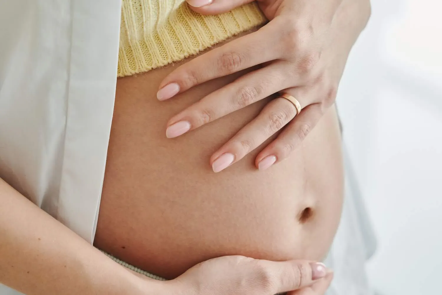 Schwangere Frau hält sich die Hände an den Bauch Schwangere Frau hält sich die Hände an den Bauch