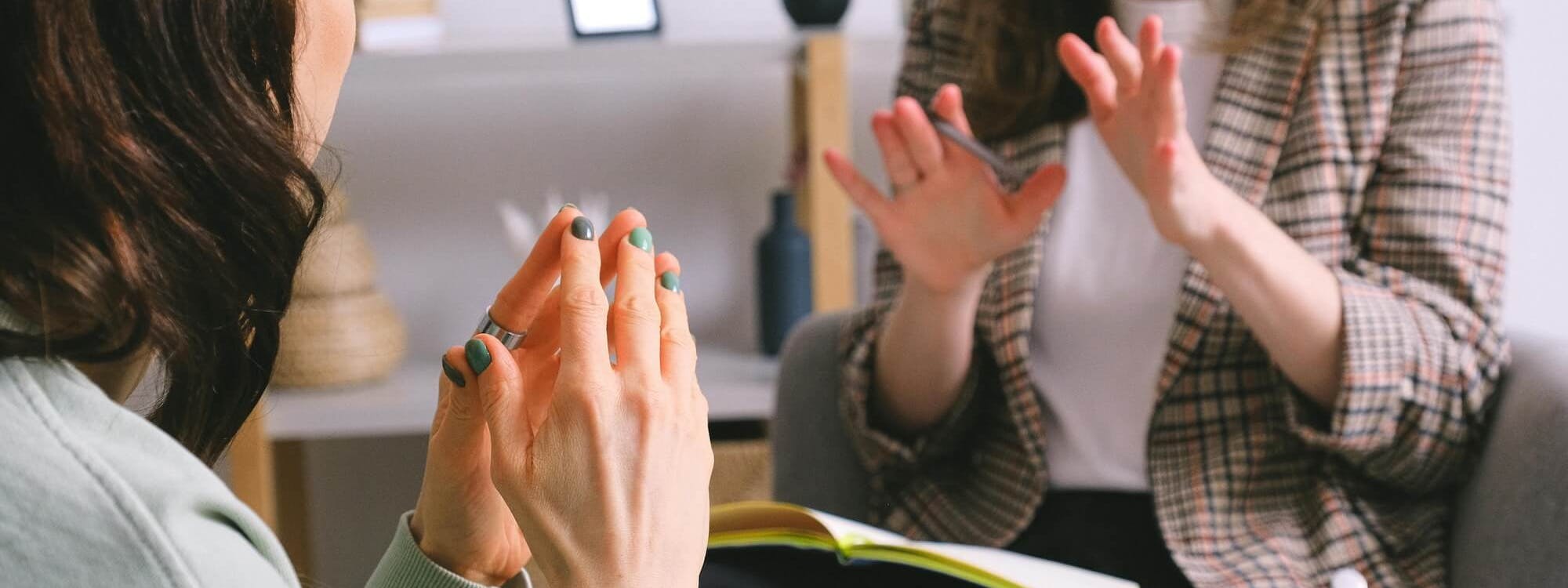 Zwei Frauen unterhalten sich in einem Therapieraum