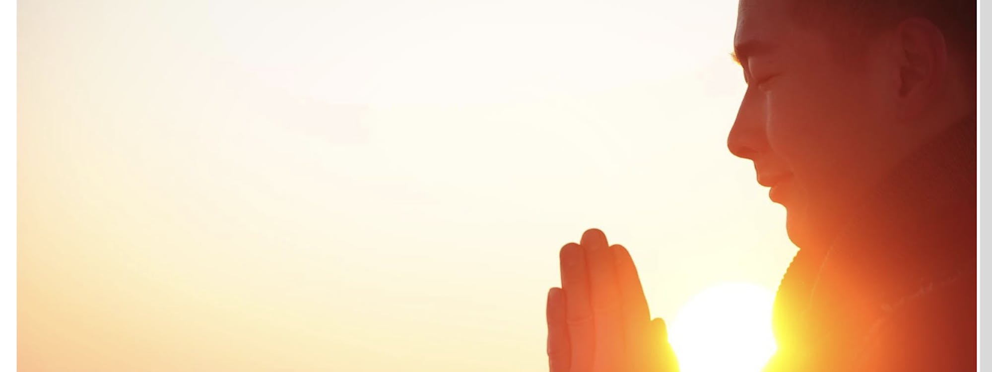 Mann meditiert beim Sonnenuntergang