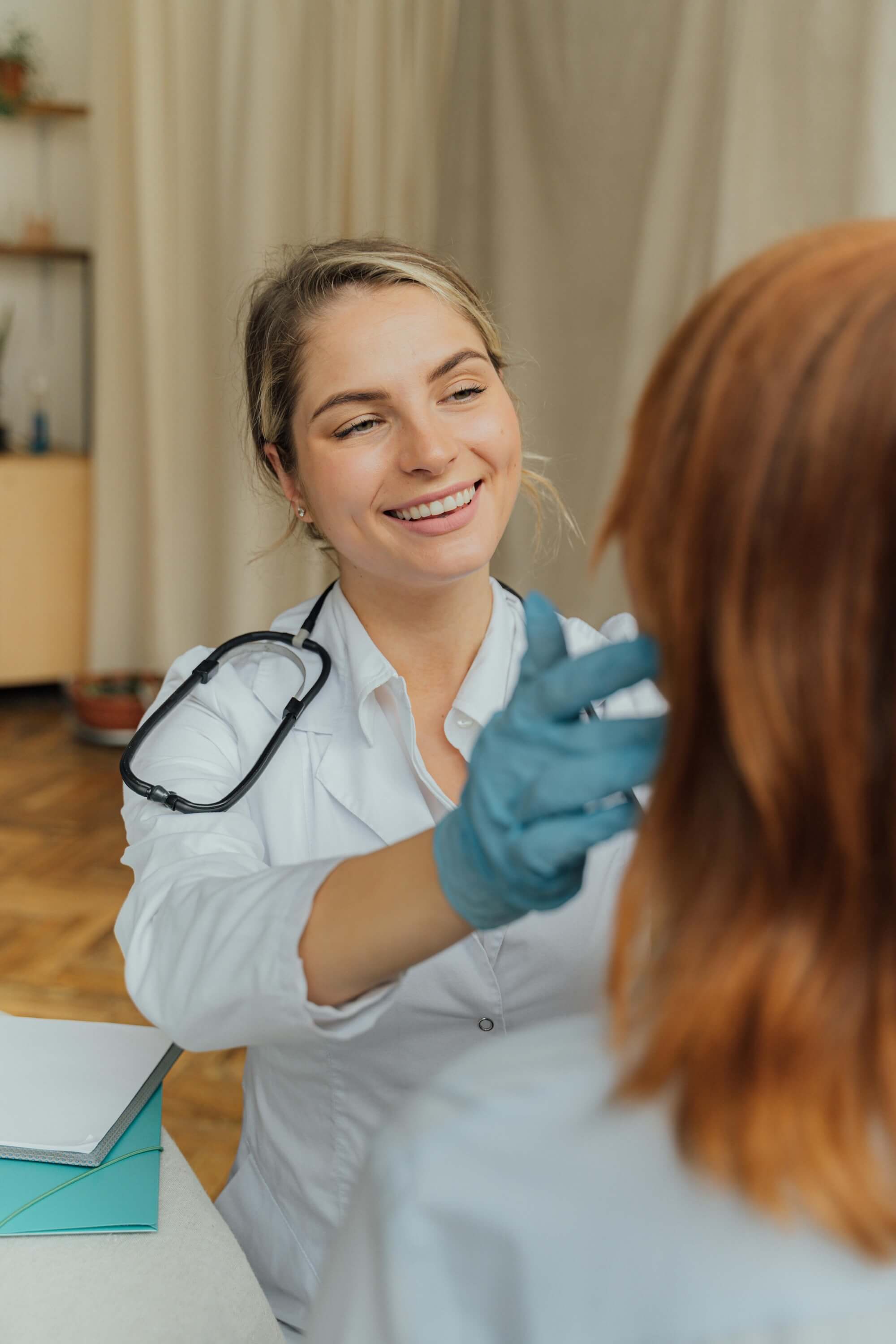 Ärztin untersucht eine Frau den Lymphknoten