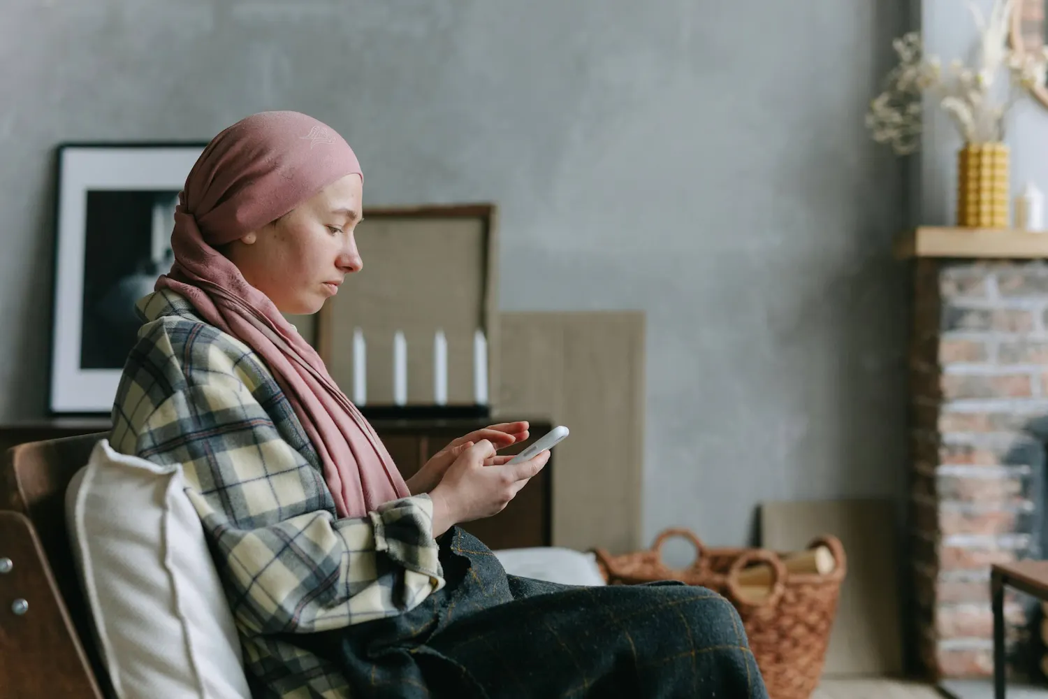 Frau mit Brustkrebs sitzt an ihrem Handy