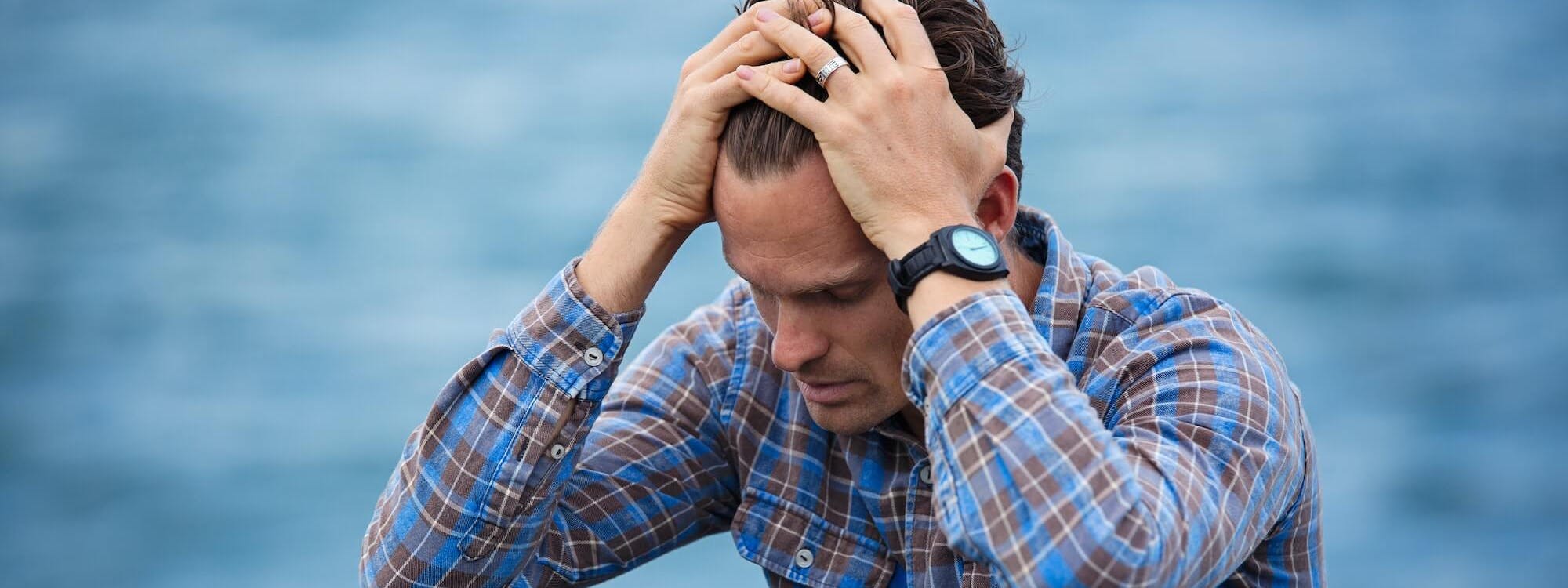 Mann mit Angst fasst sich an den Kopf