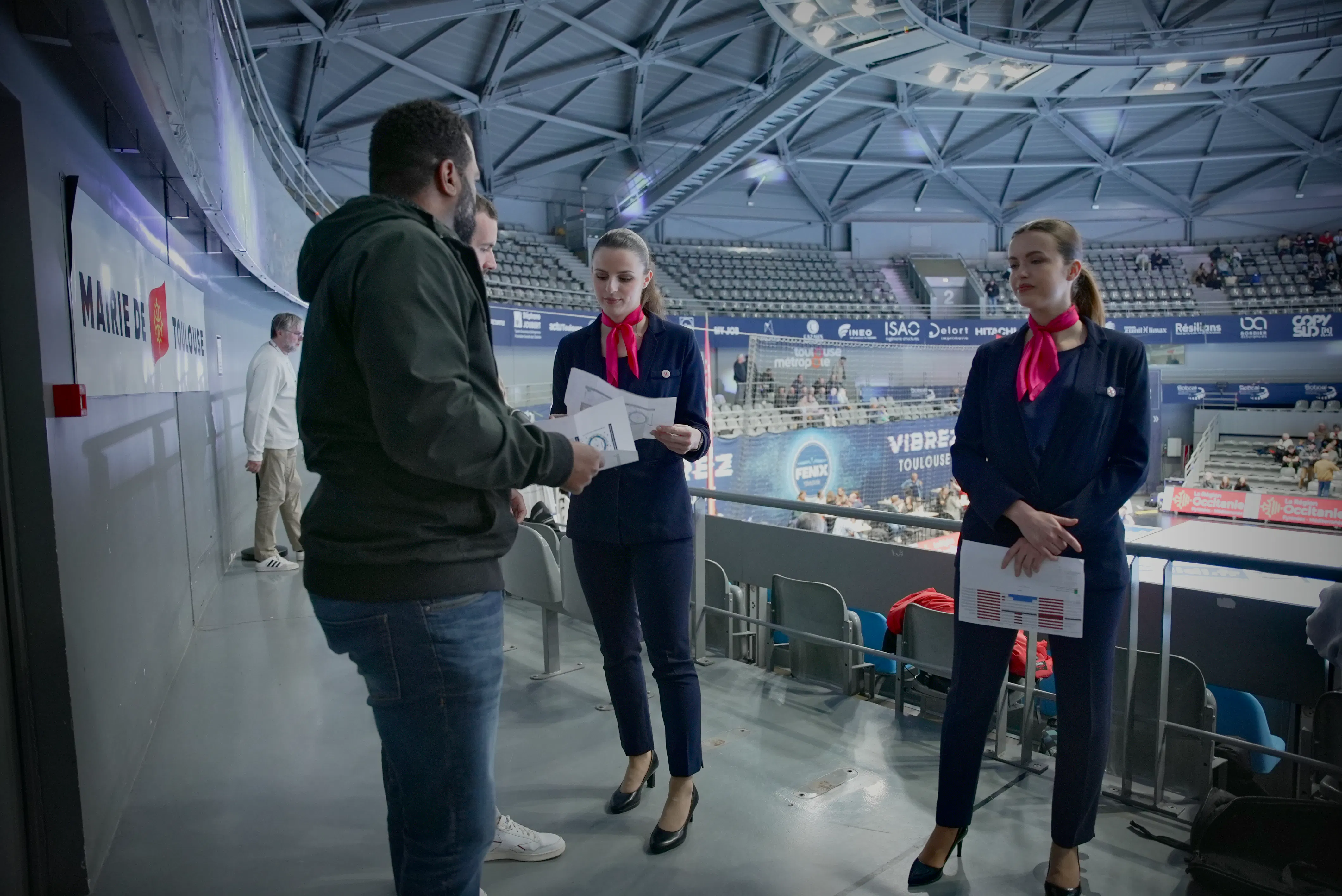 Hôtes et hôtesses d'accueil assurent l'orientation des invités lors d'un match