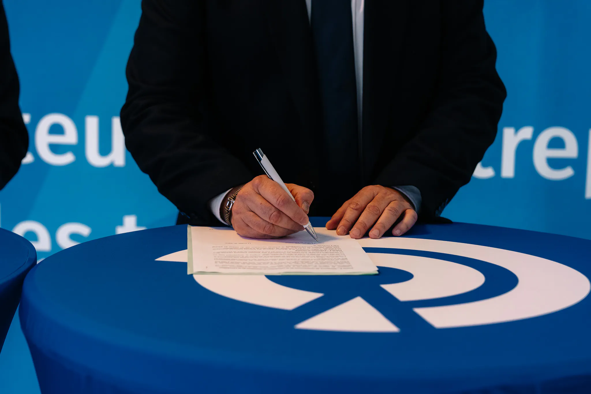 Tables brandées avec logo et identité visuelle de la marque lors d’un événement corporate organisé par une agence.