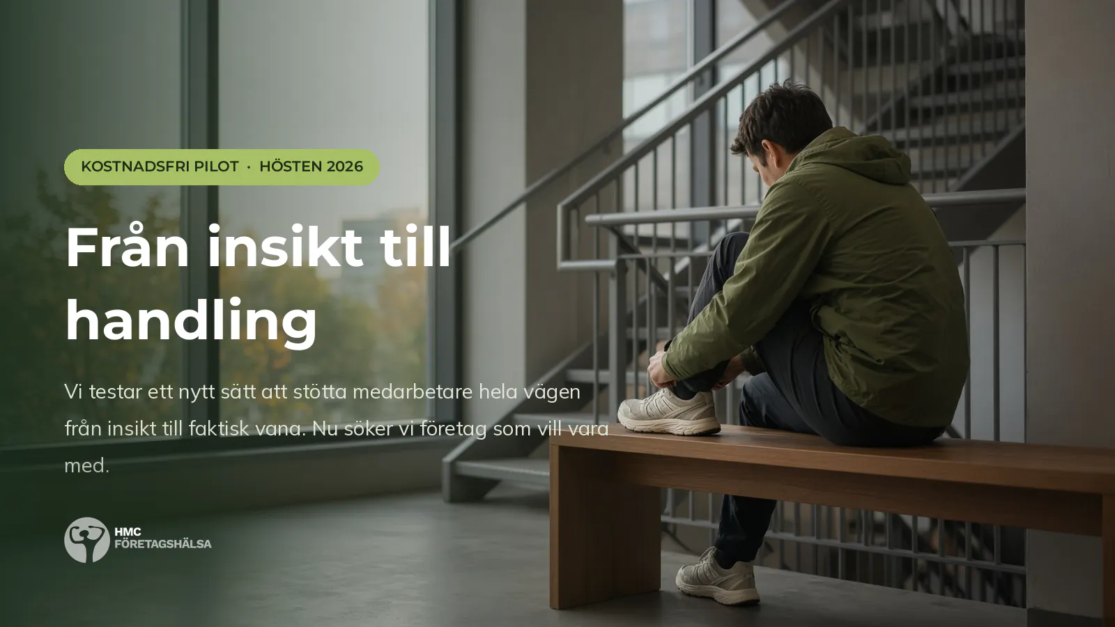 Person i grön jacka knyter löparskon på en bänk i ett kontorstrapphus, med höstljus genom fönstret.