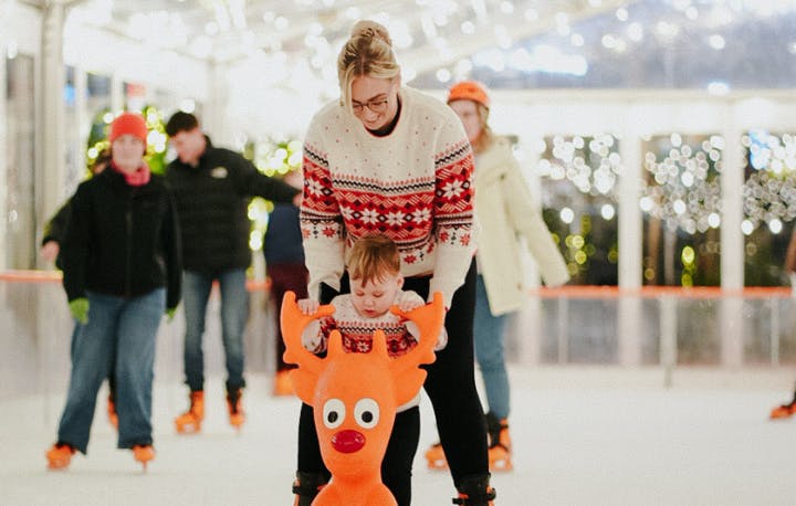 people ice skating on ice rink, with a Rudolph skating aid