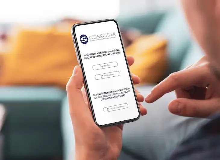Eine Person bedient auf ihrem Smartphone eine Anmeldeseite mit weißen Eingabefeldern.