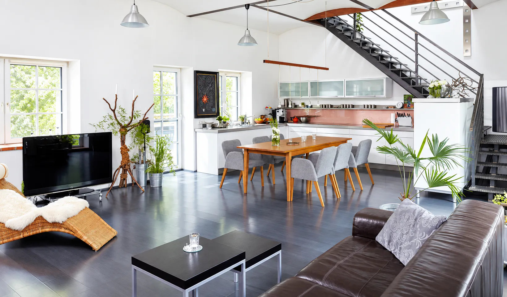 Moderner offener Wohn- und Essbereich mit Küche, Treppe und hochwertiger Innenausstattung als Beispiel für Sanierung und Renovierung von Wohnimmobilien.