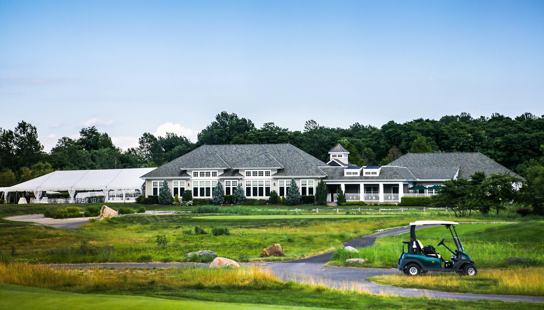 Harbor Links clubhouse with part of the golf course and a golf cart in the foreground.