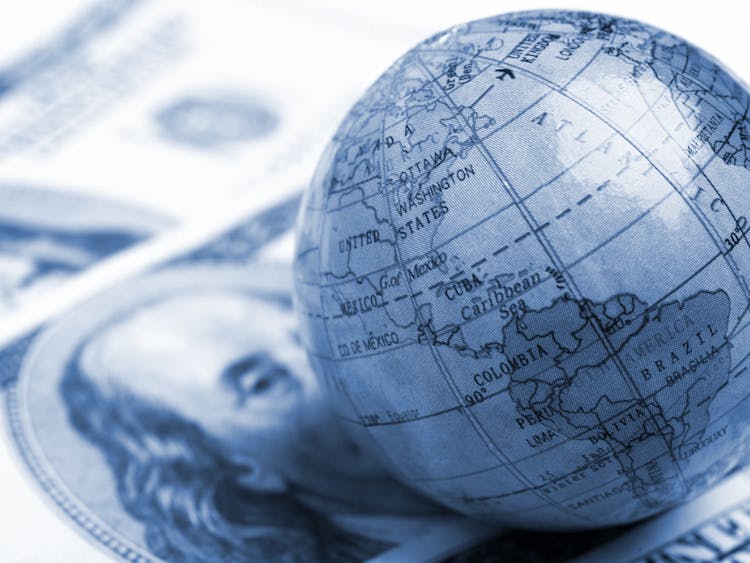 A globe sitting on top of a pile of money.