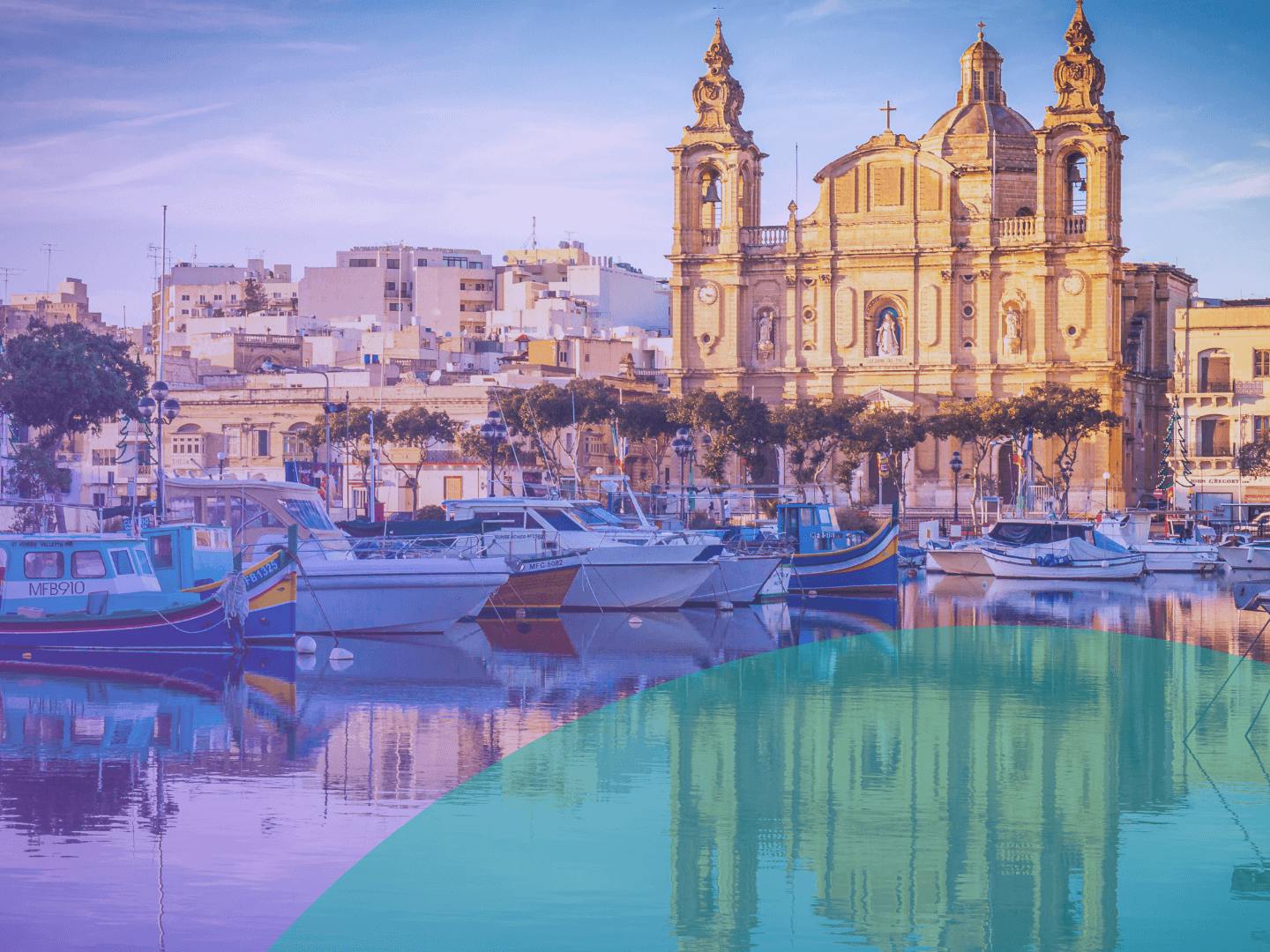 A Maltese-style building with boats nearby. There is a reflection of the view on the sea.
