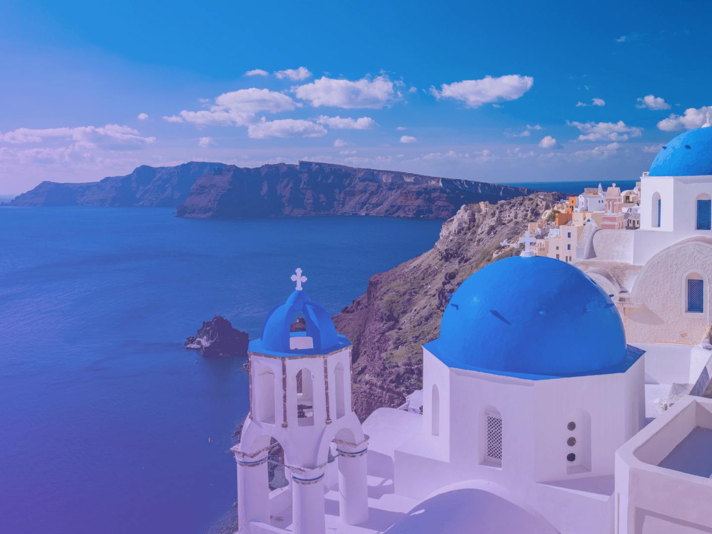 A blue and white church with a view of the sea in Greece.