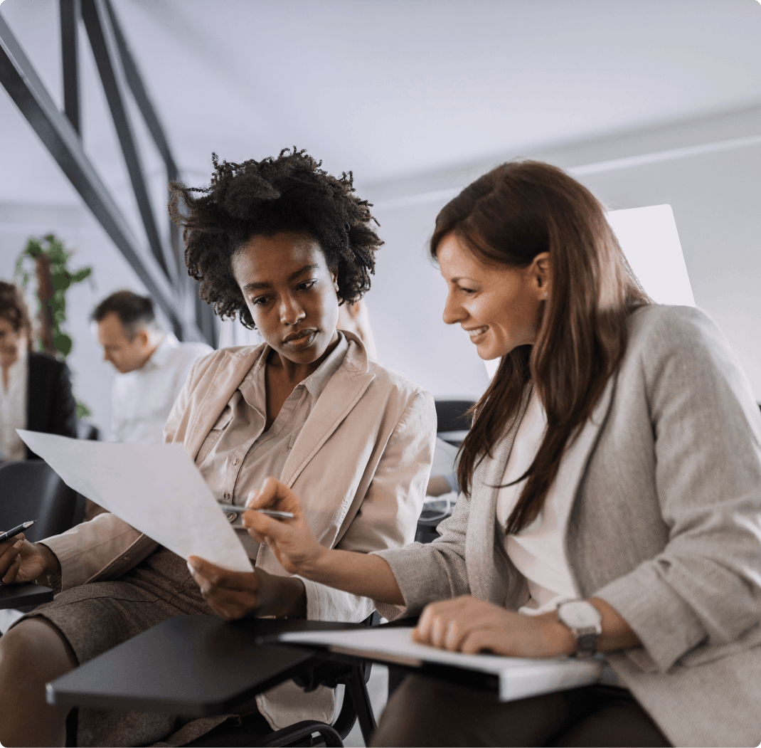 Dos mujeres examinan un papel.