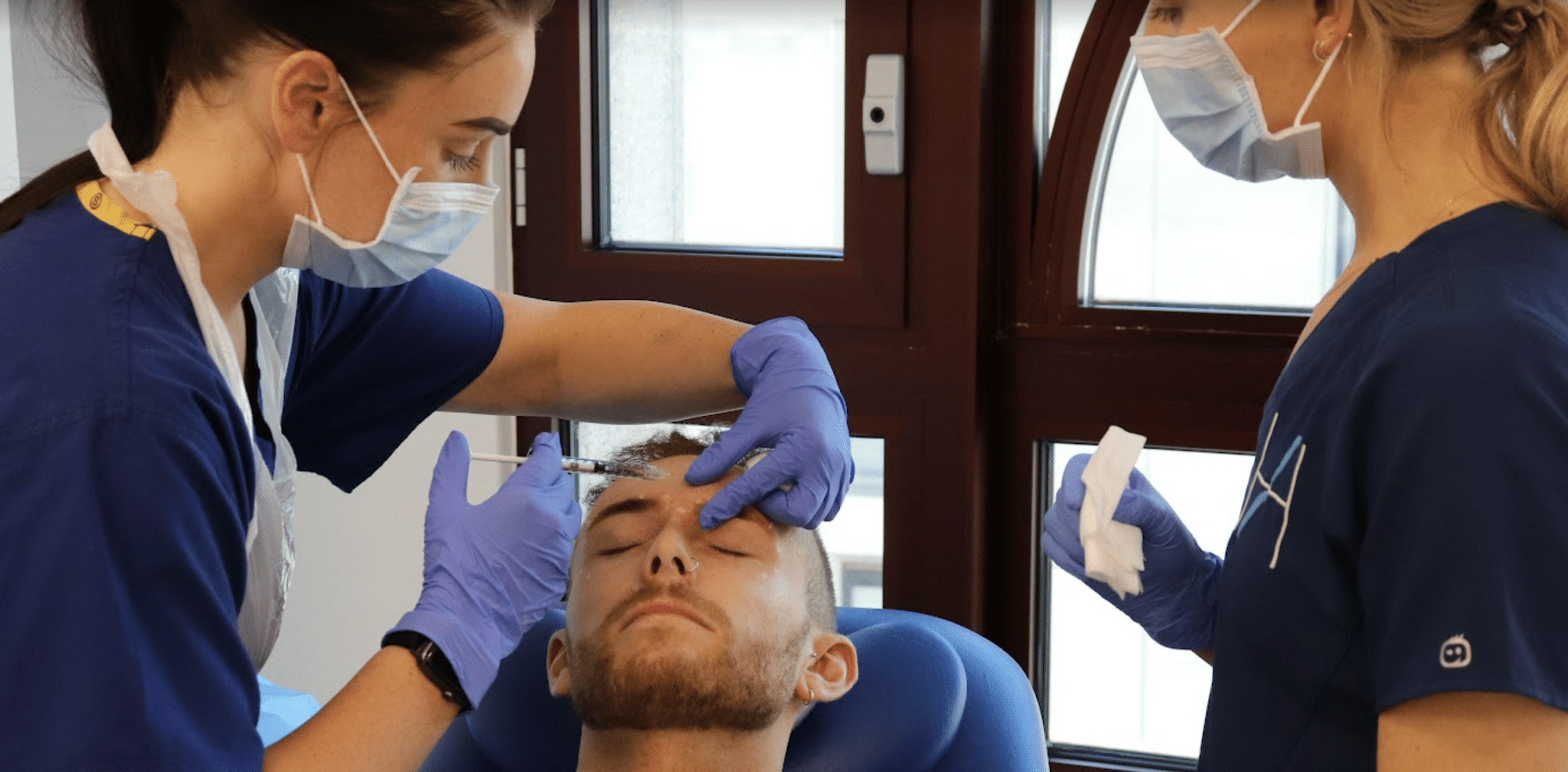 A male patient receiving botox injectors into the forehead area