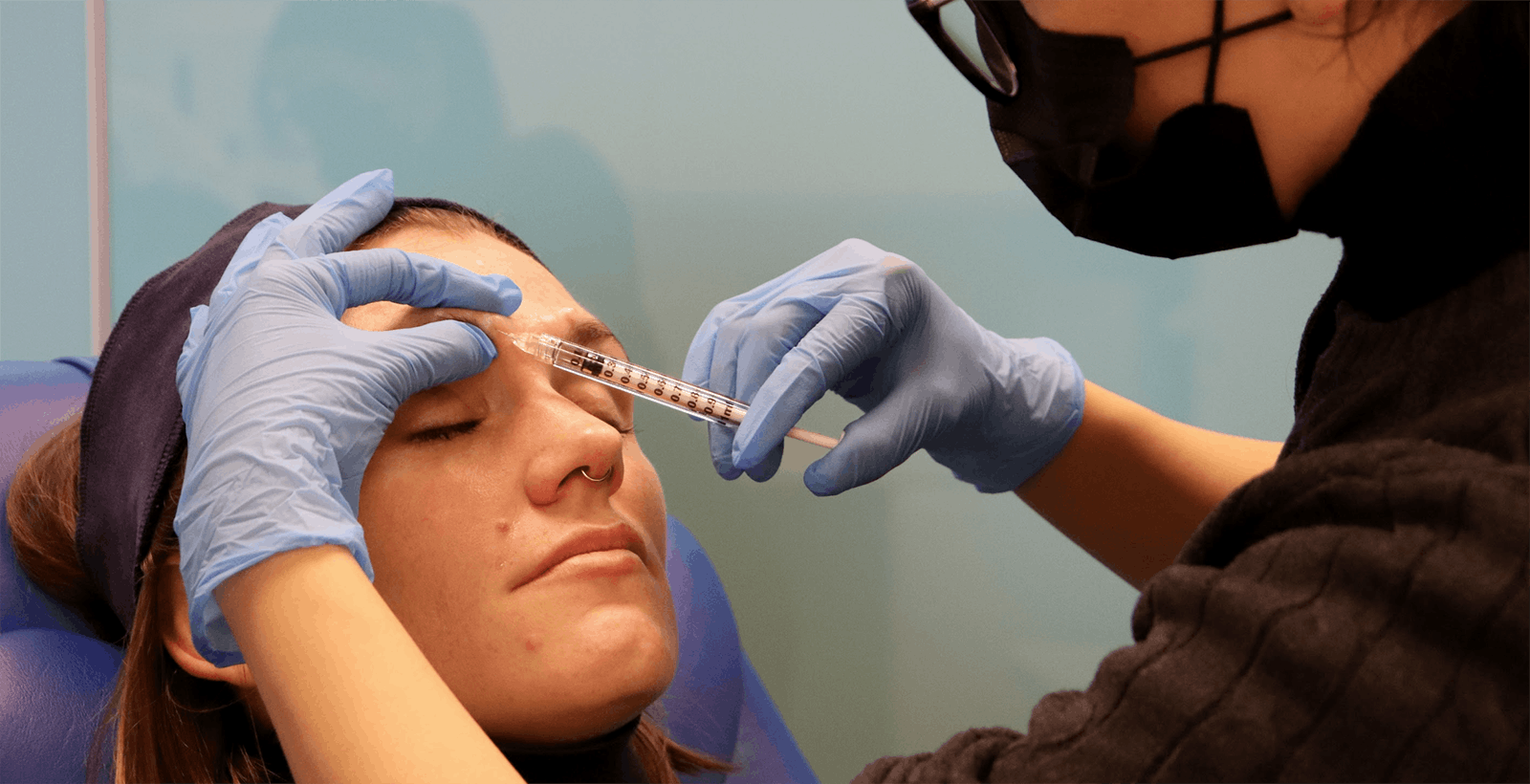 An image of a female patient receiving forehead injectable treatment