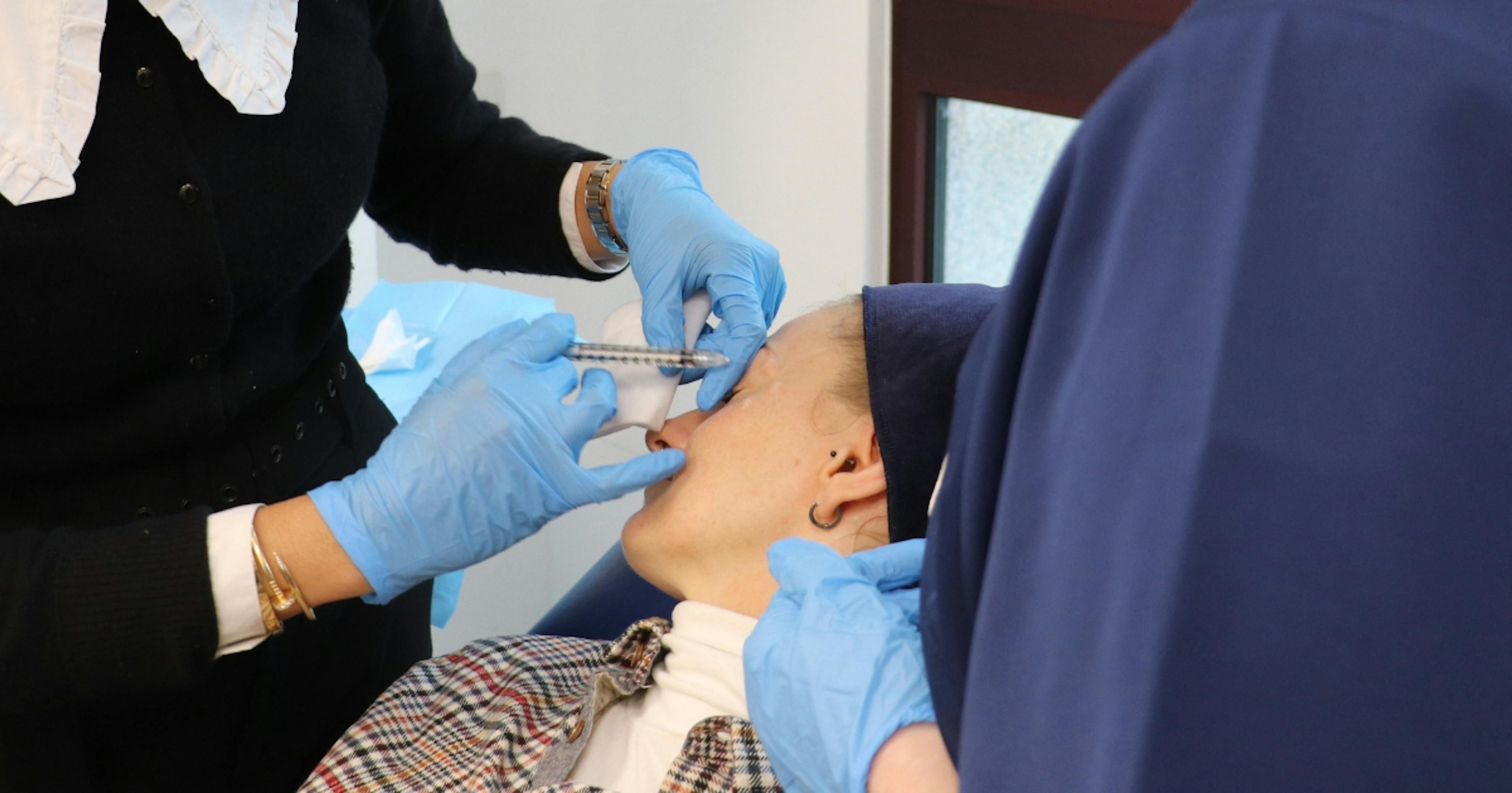 Injecting botox into the crow's feet lines around the eye at Harley Academy