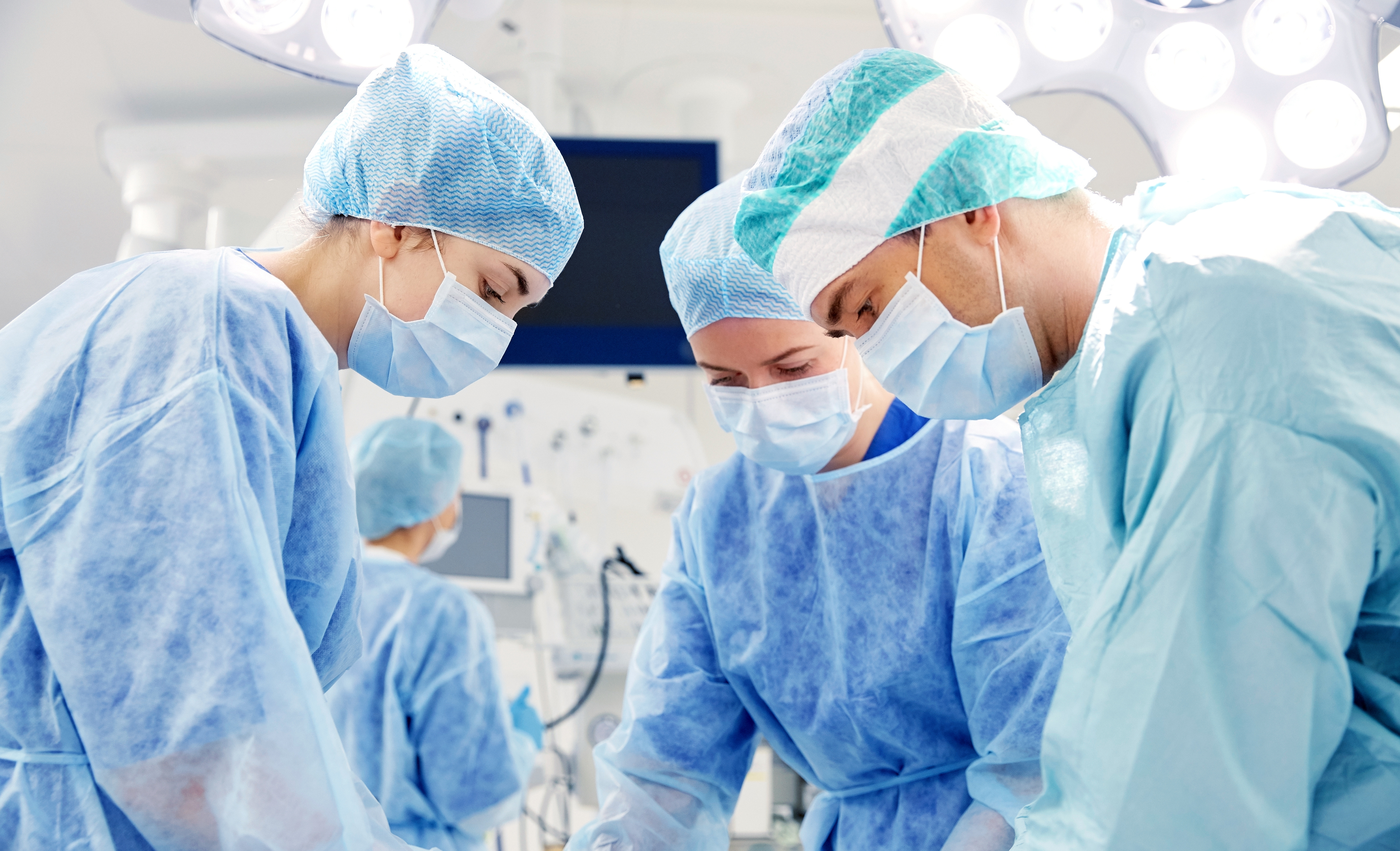 Three surgeons in the operating room during a procedure