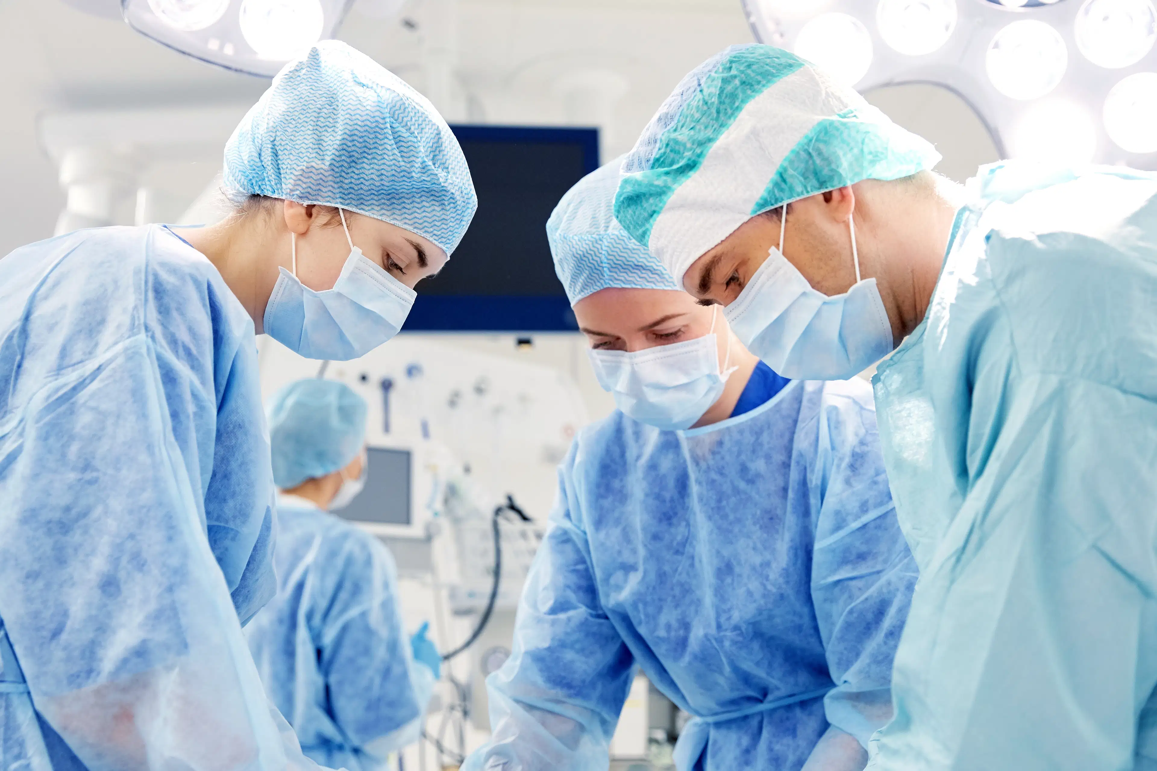 Three surgeons in the operating room during a procedure