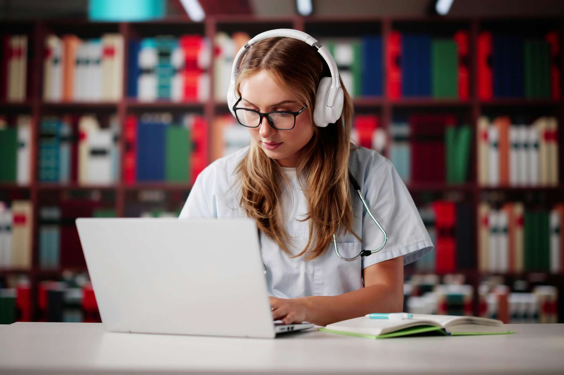 Female student with headphone on looking at something on her laptop