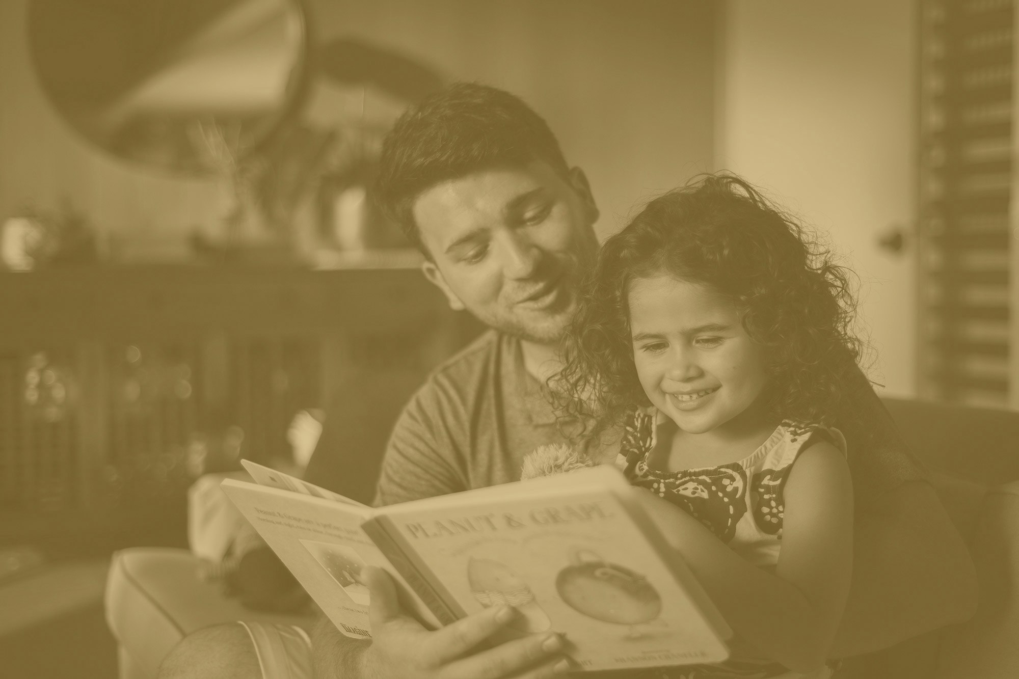 father reading daughter a children's book