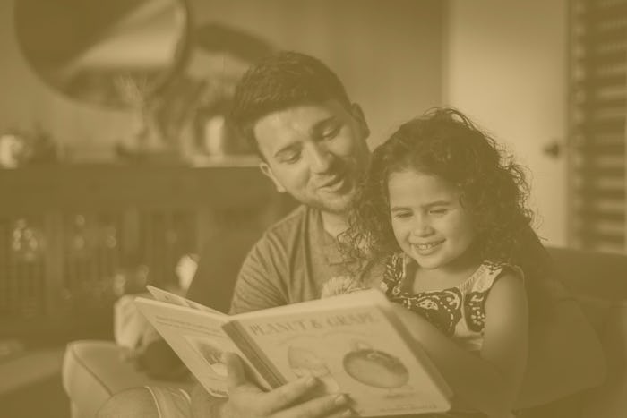 father reading daughter a children's book