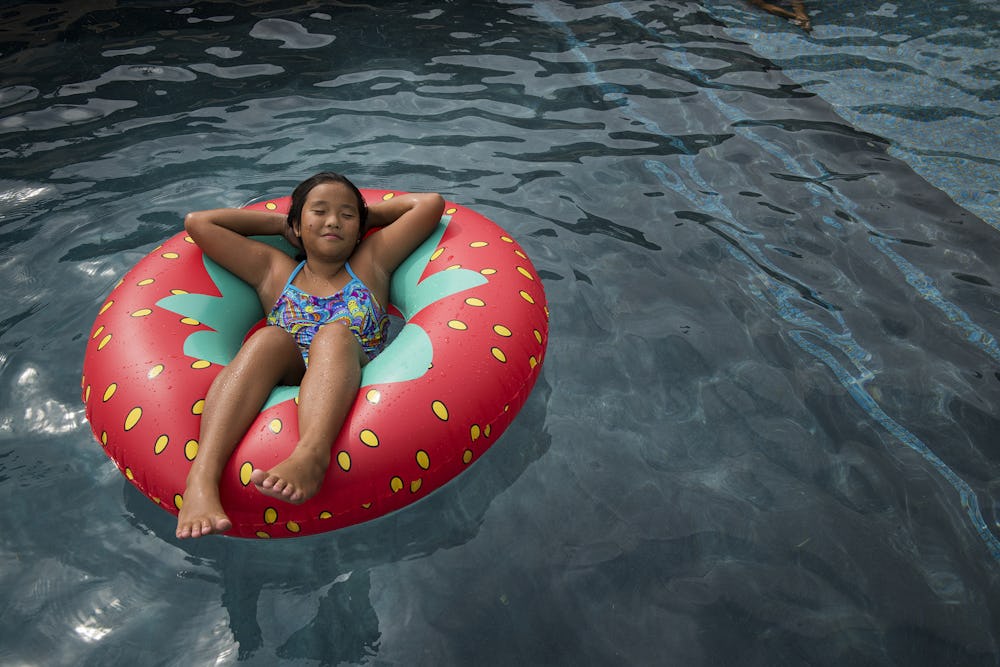 girl lounging on inflatable floatation device in pool