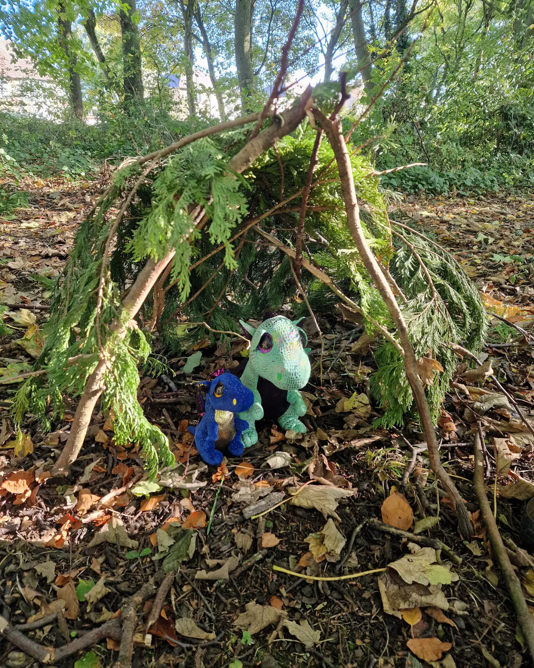 Toy dragons in a den made of sticks and leaves